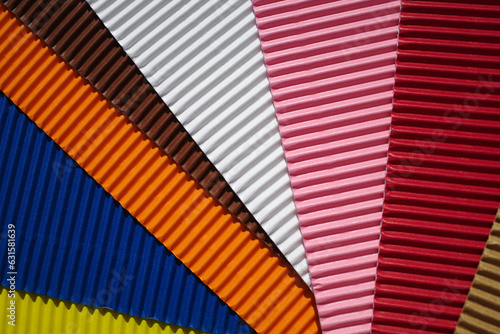 Set of diagonally ribbed cardboard pieces in the colors yellow, dark blue, orange, brown, white, pink, red and beige. Meant as background