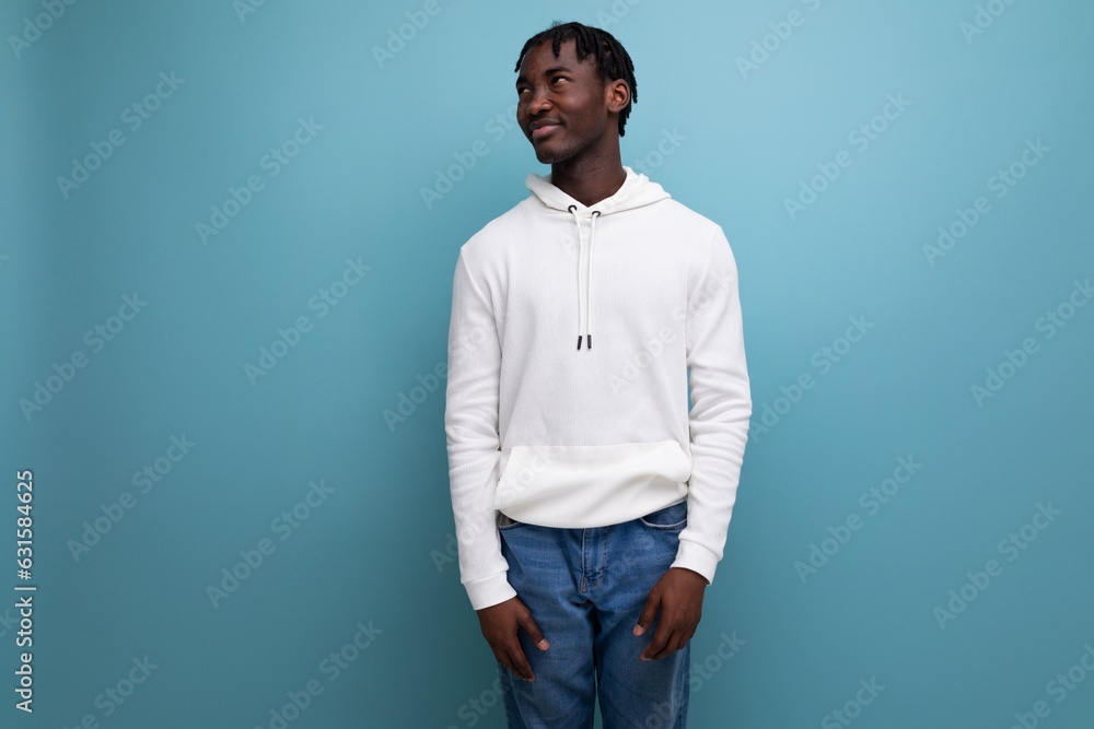 active american young man with dreadlocks in a white sweater inspired on a blue background active american young man with dreadlocks in a white sweater inspired on a blue background