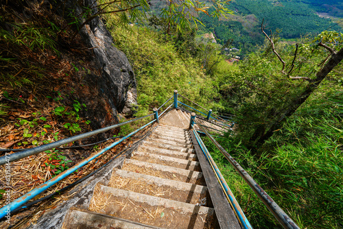 Steep stairs climbing up a limestone karst cliff through the rainforest to the mountaintop pagoda of the Wat Tham Suea aka the Tiger Cave Temple of Krabi in the south of Thailand