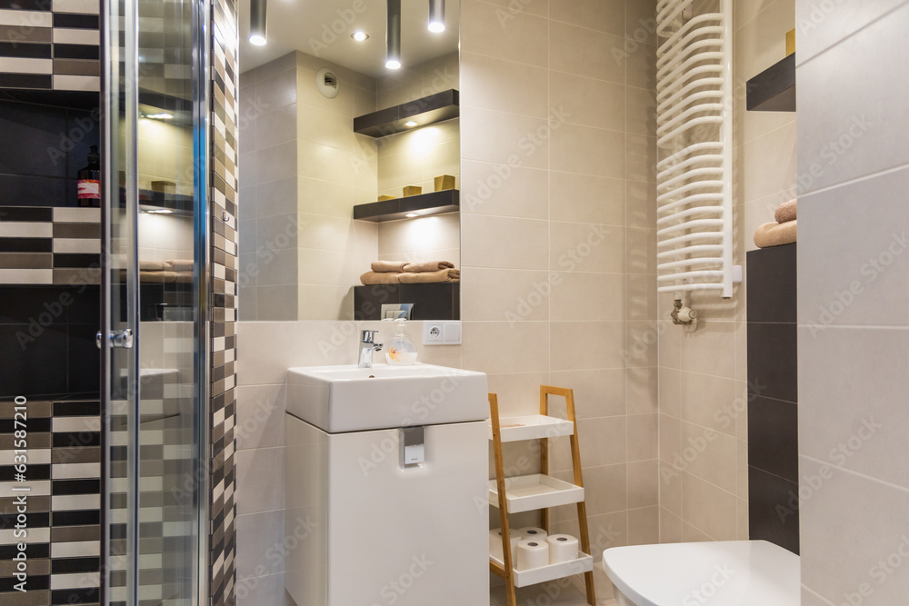 Modern interior of new studio apartment with modern decorations, big toilet with shower and washing machine, equipped kitchen with coffee machine and big bed with tv in front of it Modern interior of new studio apartment with modern decorations, big toilet with shower and washing machine, equipped kitchen with coffee machine and big bed with tv in front of it