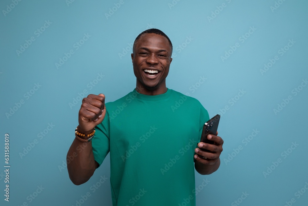 young handsome american guy dressed in a basic t-shirt uses a smartphone young handsome american guy dressed in a basic t-shirt uses a smartphone
