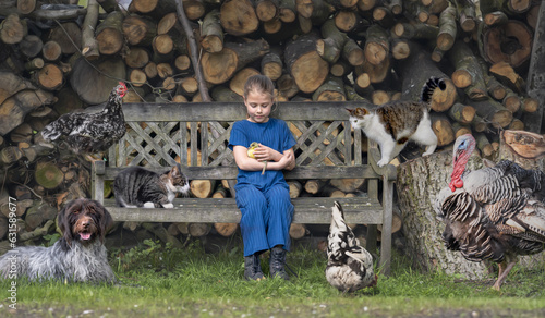 Young child sitting outside with a lot of pets: baby goose, chickens, cats, turkey and a dog. Holding a cute chick. Friendship, bonding, care.  photo