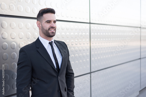 businessman in suit at silver building wall