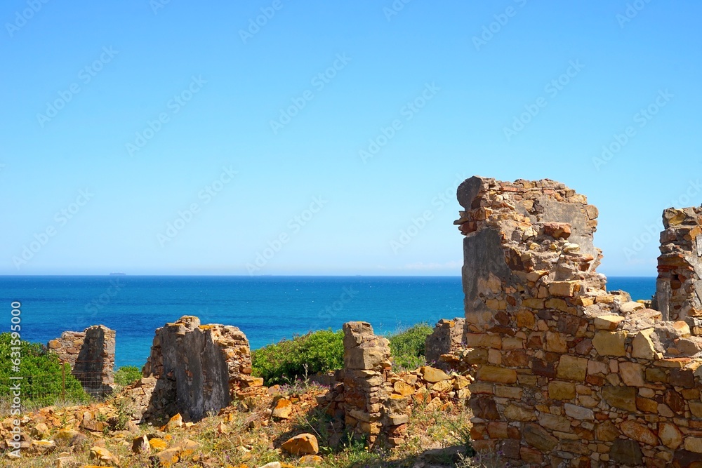 old stone ruins walls in front of the blue Mediterranean Sea near La Alcaidesa in Andalusia, Spain