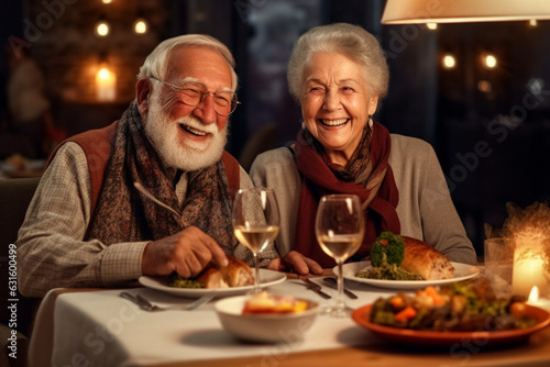 Smiling elderly couple sits at table with candles and dinner in anniversary