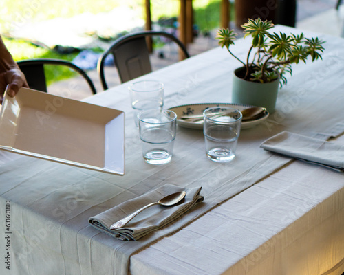 Setting the Table: Woman arranging with tablecloth, plates, and cutlery photo