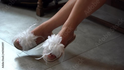 Kobiece nogi w damskich białych pantoflach photo