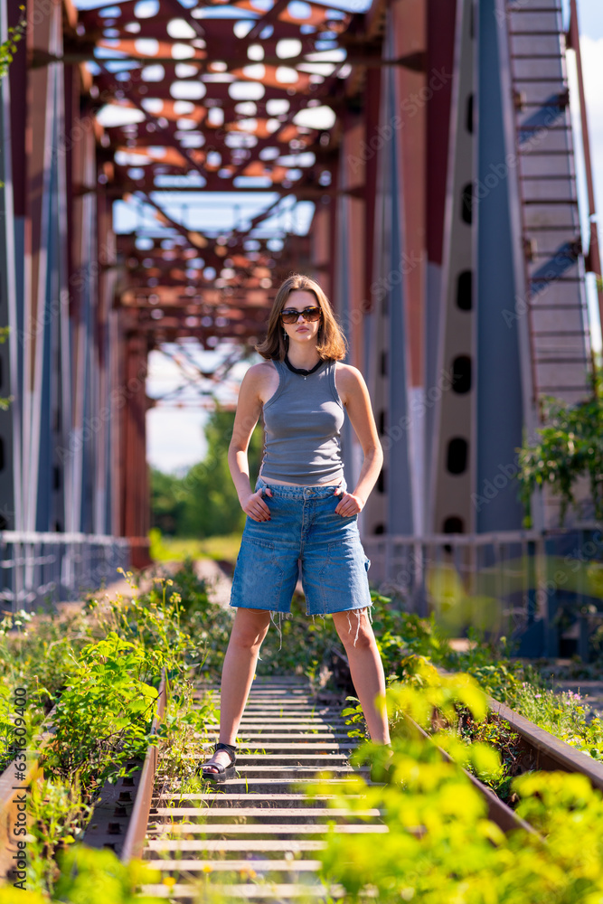 Young woman looking at the camera while standing on a bridge
