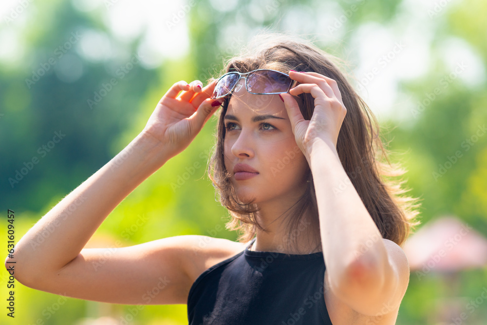 Young woman adjusting her sunglasses