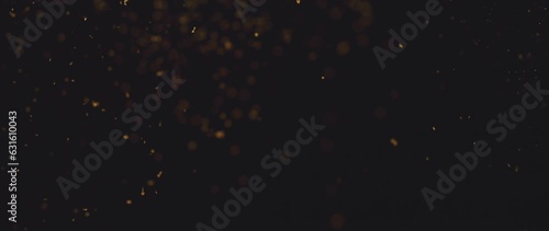 Soaring small pieces of golden dust are sparkling on black background photo