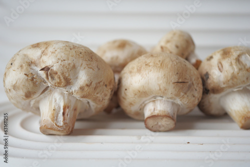 Fresh champignons mushroom in a white bowl on table 