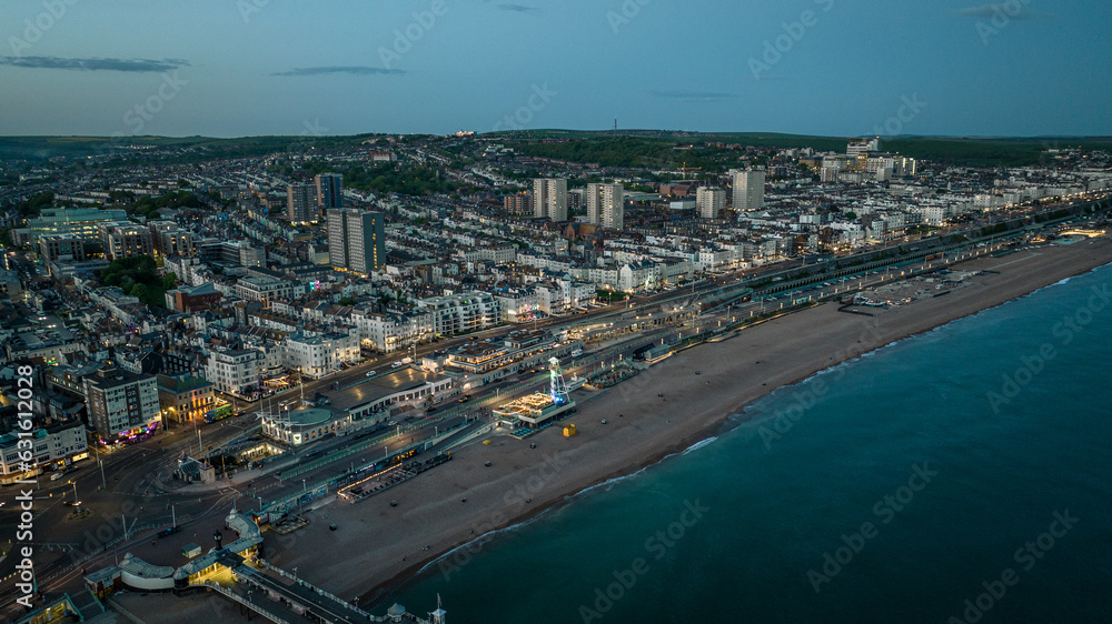 Brighton beach and evening lights of the town, Brighton and Hove, East Sussex, UK