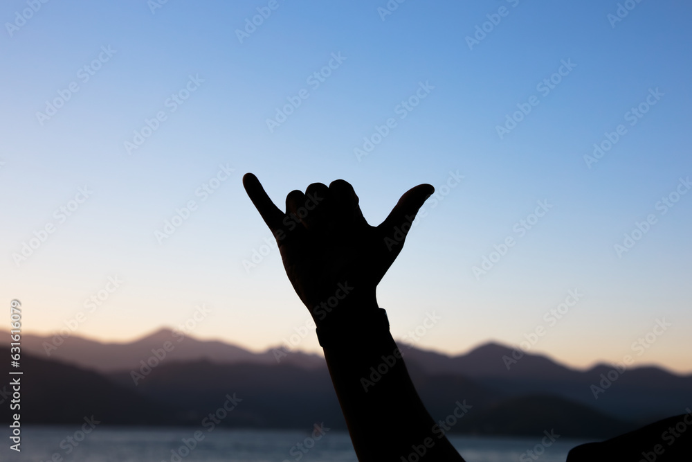 Fototapeta premium silhouette of hands against a beautiful colorful late afternoon sky in Rio de Janeiro.