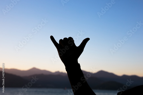 silhouette of hands against a beautiful colorful late afternoon sky in Rio de Janeiro.