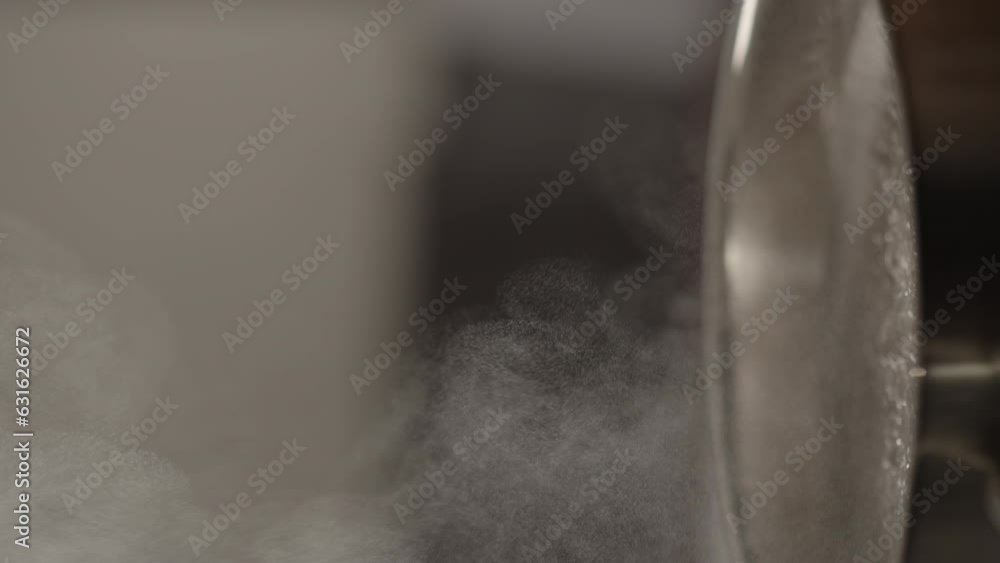 Slow motion vertical shot of steam rising from steel saucepan on stove Slow motion vertical shot of steam rising from steel saucepan on stove