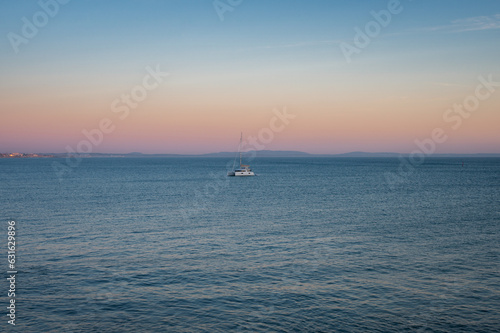 Aerial view of a sailboat in the sea at sunset in Cascais, Portugal  © Luis