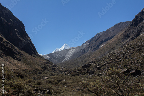 Punta del nevado pirámide de la laguna de Parón en Áncash, cerca de Huaraz, paisaje rodeado de rocas negra y la punta del nevado al final photo
