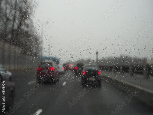 
Timelapse (fast motion) of defocused heavy traffic in the city on a winter day, focus on drops on the glass. Camera shaking vibration.