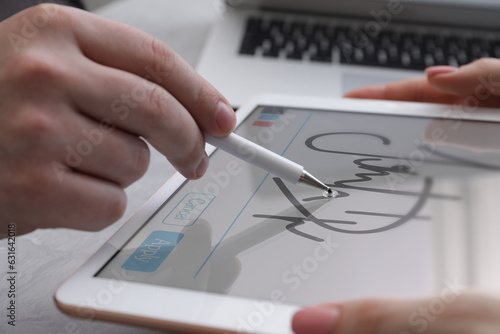 Electronic signature. Man using stylus and tablet at table, closeup