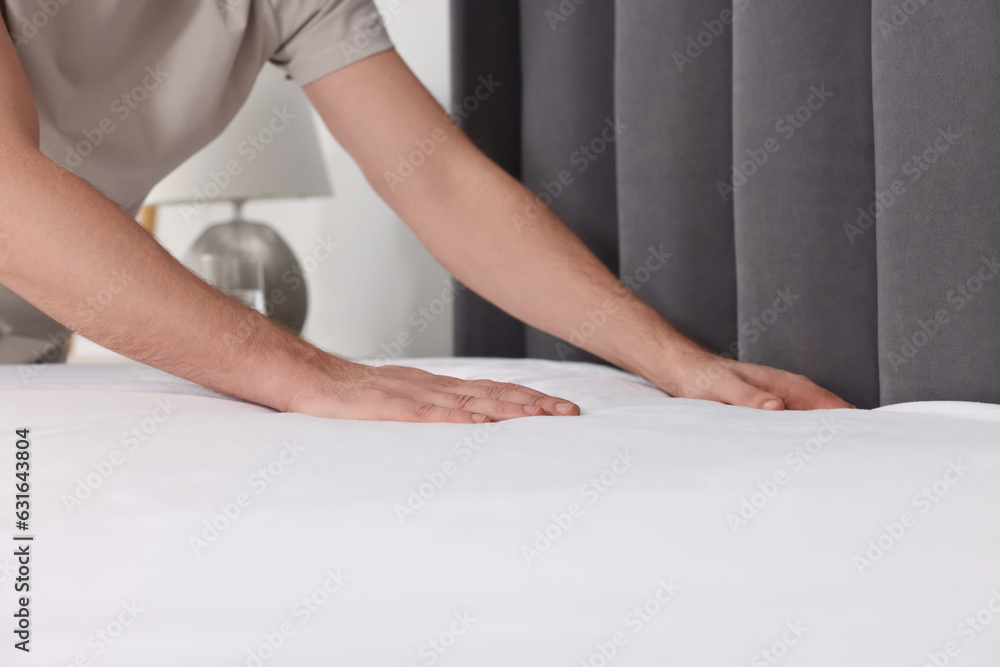 Man changing bed linens at home, closeup