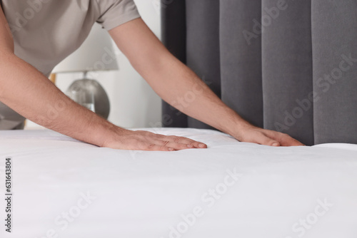 Man changing bed linens at home, closeup