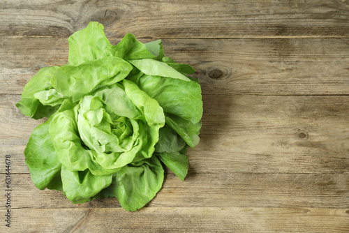 Fresh green butter lettuce on wooden table, space for text
