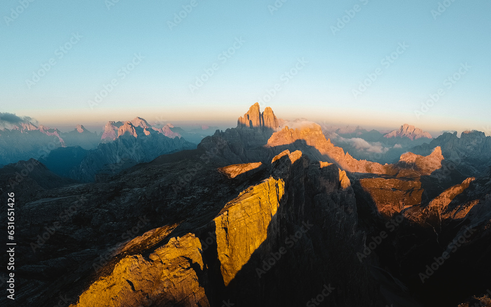 Aerial view over Tre cime region in the Sexten Dolomites, Northern Italy. Taken during beautiful, colorful sunrise. Aerial view over Tre cime region in the Sexten Dolomites, Northern Italy. Taken during beautiful, colorful sunrise.