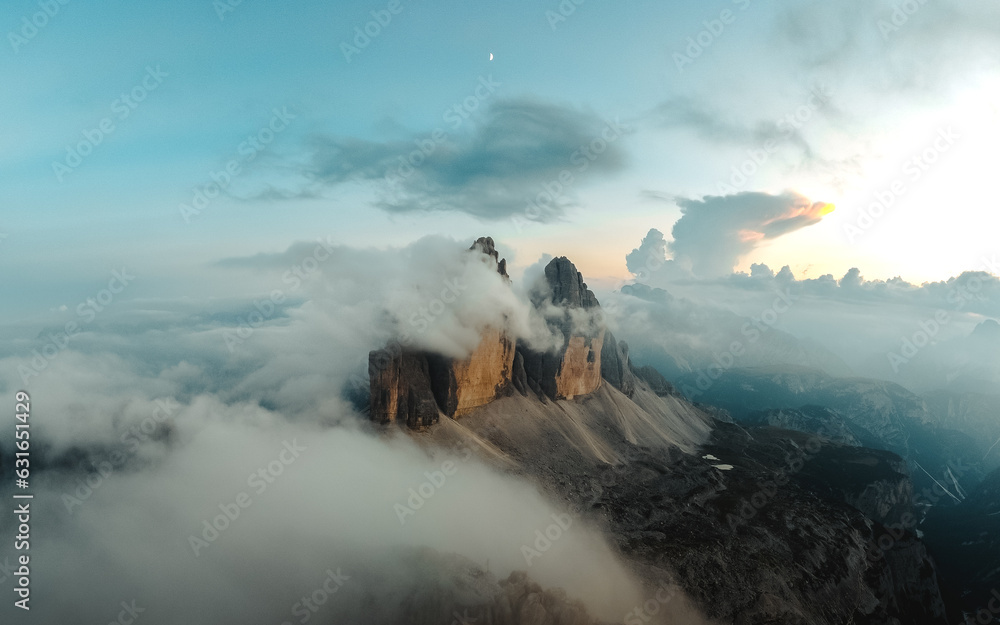 Fototapeta premium Majestic Tre Cime di Lavaredo being revealed in a dramatic light with low clouds.