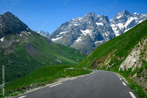 Narrow mountains road from Col de Lautaret to Col du Calibier, Mountains and alpine meadows views of Massif des Ecrins, Hautes Alpes, France in summer photo