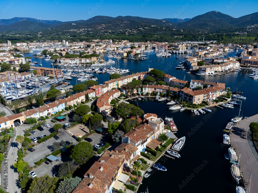 Arial view on blue water of Gulf of Saint-Tropez, boats, houses in Port Grimaud and Port Cogolin, villages on Mediterranean sea with yacht harbour, Provence, summer in France