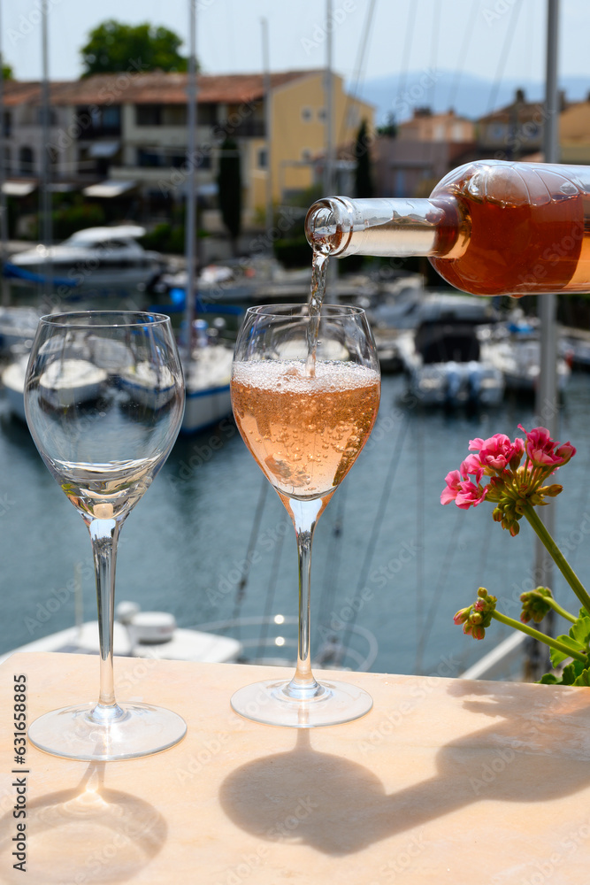 Pouring in glasses of cold rose Cote de Provence wine in yacht harbour of Port Grimaud, summer vacation on French Riviera Provence, France Pouring in glasses of cold rose Cote de Provence wine in yacht harbour of Port Grimaud, summer vacation on French Riviera Provence, France