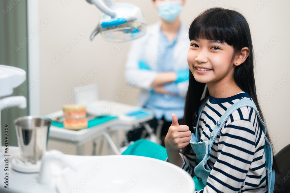 Children's dentistry for healthy teeth .Close-up happy little child asian girl smiles looking at camera, sitting in dentist's chair, receiving dental. Children's dentistry for healthy teeth .Close-up happy little child asian girl smiles looking at camera, sitting in dentist's chair, receiving dental.