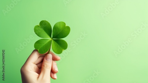 Close up hand holding four leaf clover on green background. © Pro Hi-Res