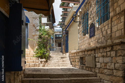 A stone staircase leading up connects two quiet streets with stone houses in the old part of Safed city in northern Israel © svarshik