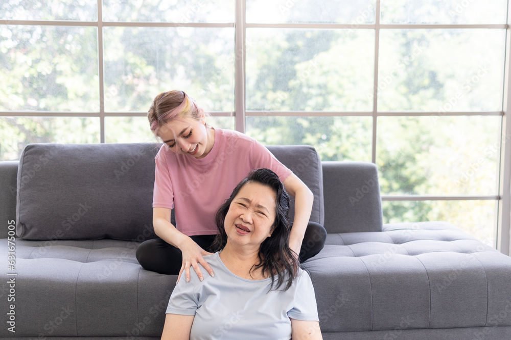 Young Asian daughter massages shoulder, relieves pain of elderly Asian mother at home Young Asian daughter massages shoulder, relieves pain of elderly Asian mother at home