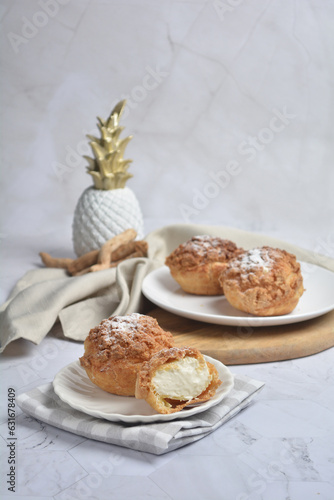 freshly handmade custard, chocolate, durian, matcha, cream puff w icing sugar cake pastry on marble luxury background with wood bamboo decoration halal food dessert menu for cafe photo