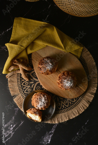 freshly handmade custard, chocolate, durian, matcha, cream puff w icing sugar cake pastry on dark luxury background with wood bamboo lantern decoration halal food dessert menu for cafe