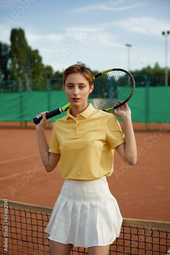 Young woman tennis player in trendy fashion sportswear posing with racket © Nomad_Soul