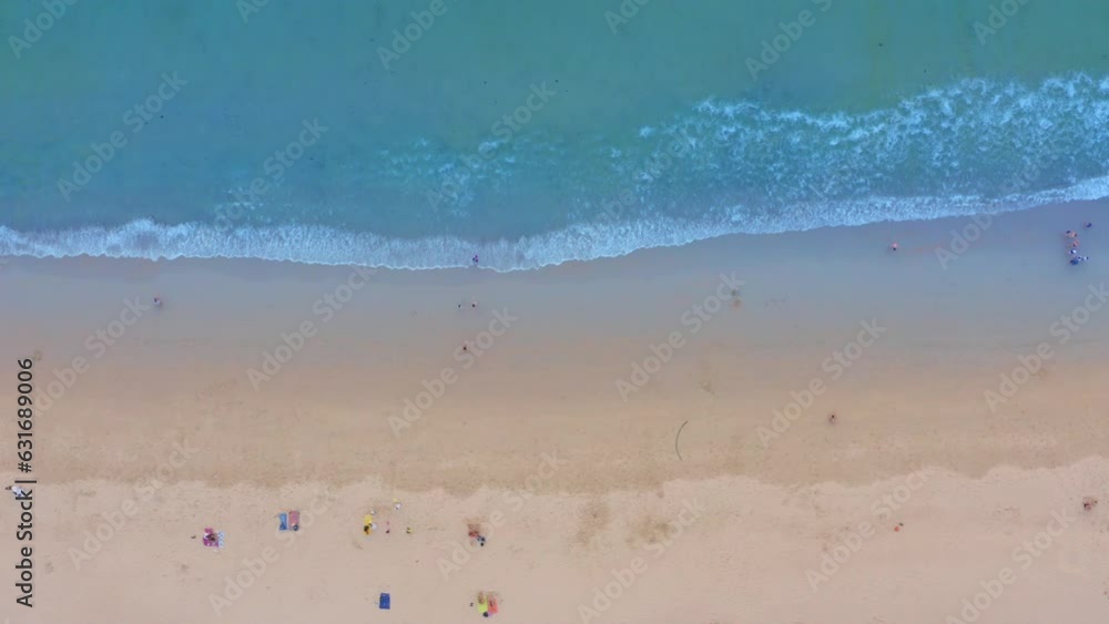 .aerial view White foam waves in the green sea lapping on the white sandy beach..Wave after wave swept towards the shore.Freedom beach Patong Phuket Thailand. .sea waves crashing on shore background .aerial view White foam waves in the green sea lapping on the white sandy beach..Wave after wave swept towards the shore.Freedom beach Patong Phuket Thailand. .sea waves crashing on shore background