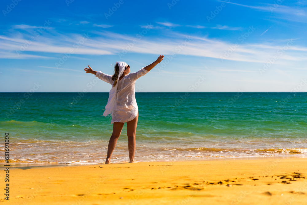 Beautiful woman walking on sunny beach
