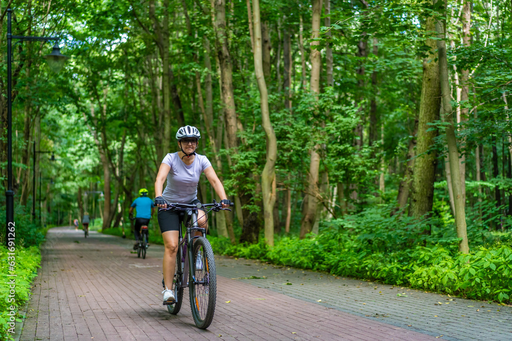 Fototapeta premium Woman riding bicycle in forest 