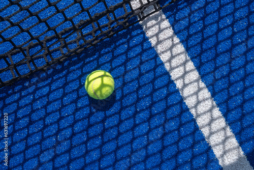 selective focus a paddle tennis balls on a blue paddle tennis court with a net in the background © Vic