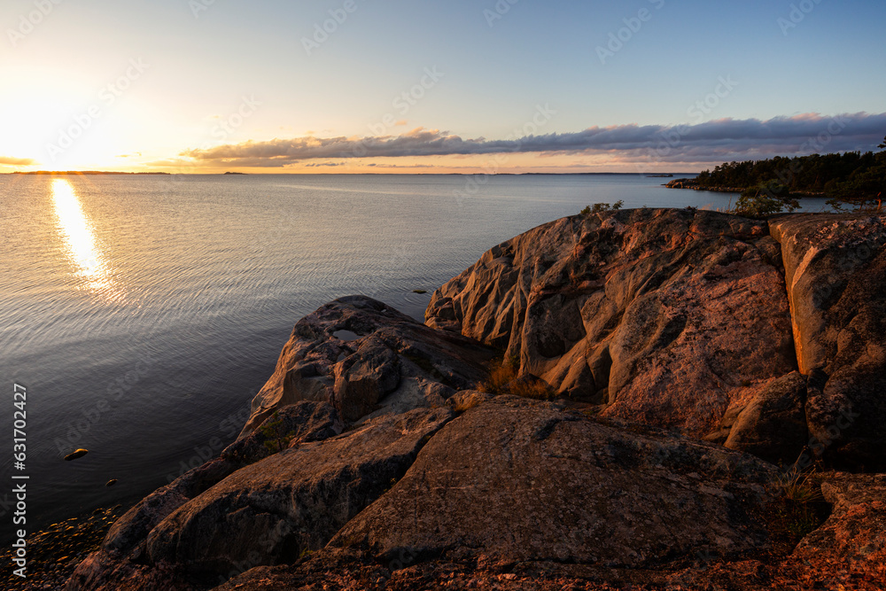 Beautiful view of rocky coastline and cliff and the Baltic Sea in Hanko, Finland, at sunset in the summer.