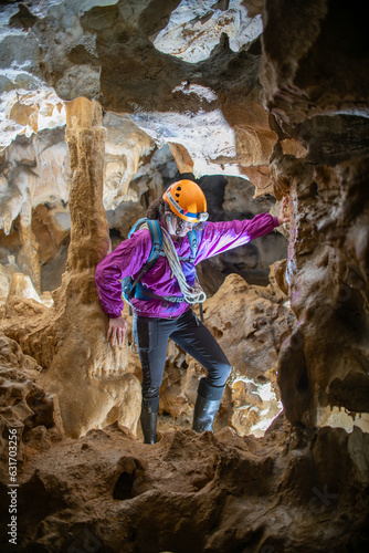 Young woman spelunking inside a cave. Feminism concept. Concept of women's sport. photo