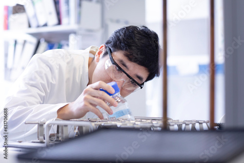 young scientist male chinese working in laboratory photo