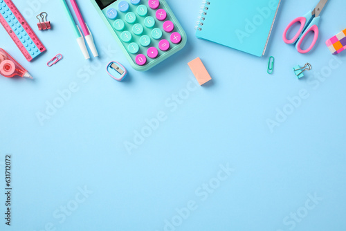 Back to school concept. Flat lay composition with girls school supplies. Top view calculator, paper notebook, pens, ruler, scissors, eraser, sharpener