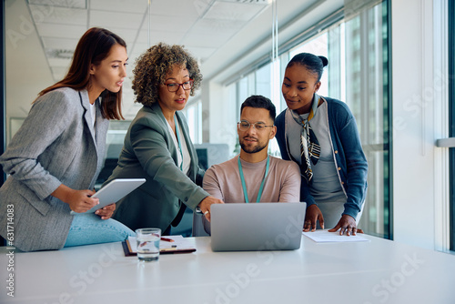 Fotografía Multiracial business team working on laptop during meeting in office