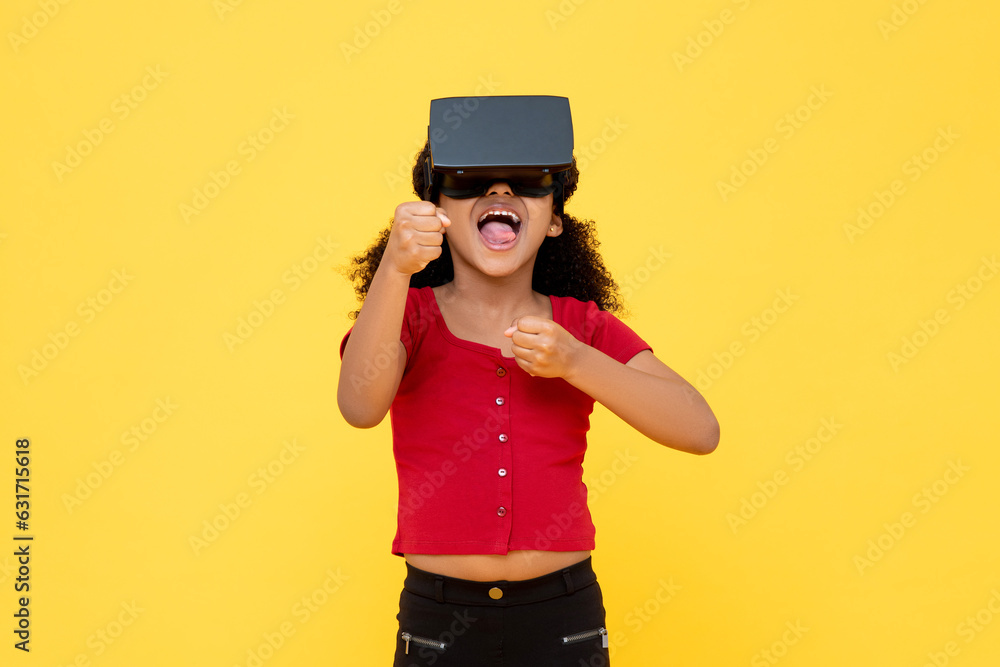 Young African American girl wearing VR glass smiling and playing in yellow color background studio shot Young African American girl wearing VR glass smiling and playing in yellow color background studio shot