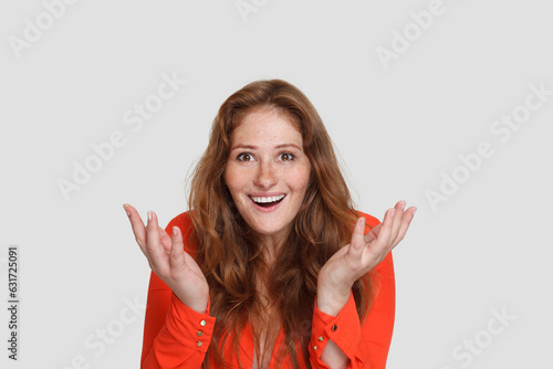 Beautiful redhead woman shacking her hands on white studio background
