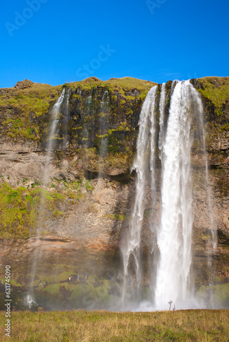 Seljalandsfoss  200-foot  volcanic glacier-fed waterfall cascading from a sheer cliff.